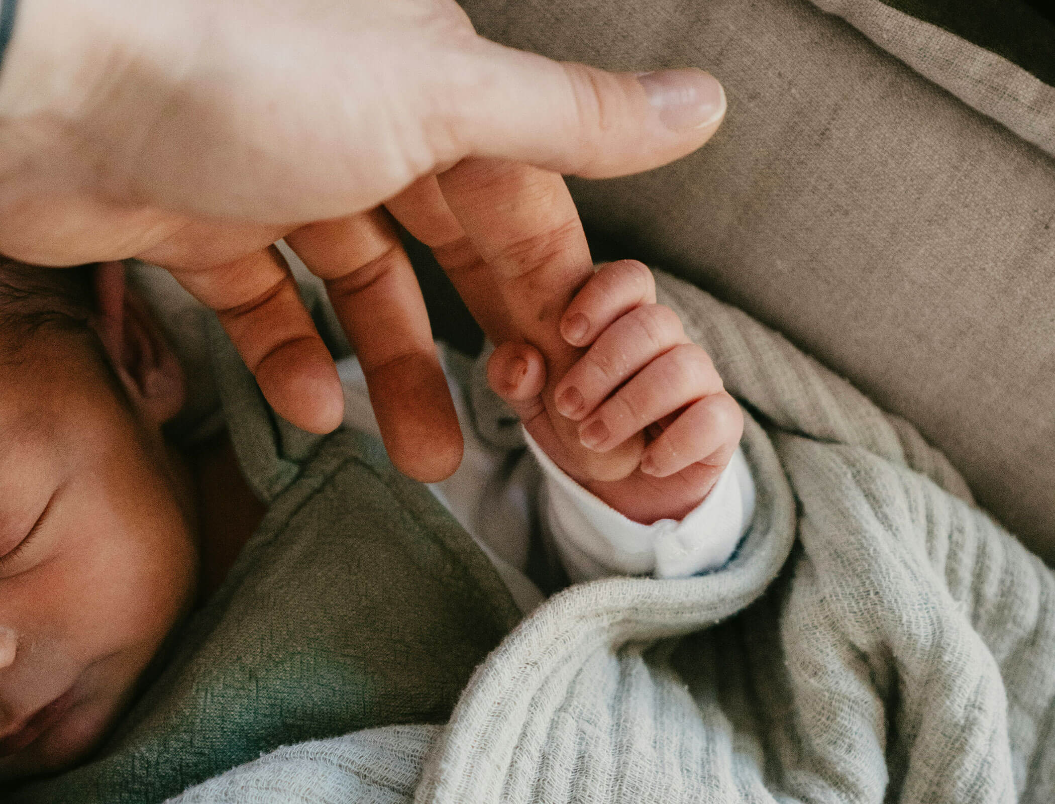 Baby hält die Hand der Mutter