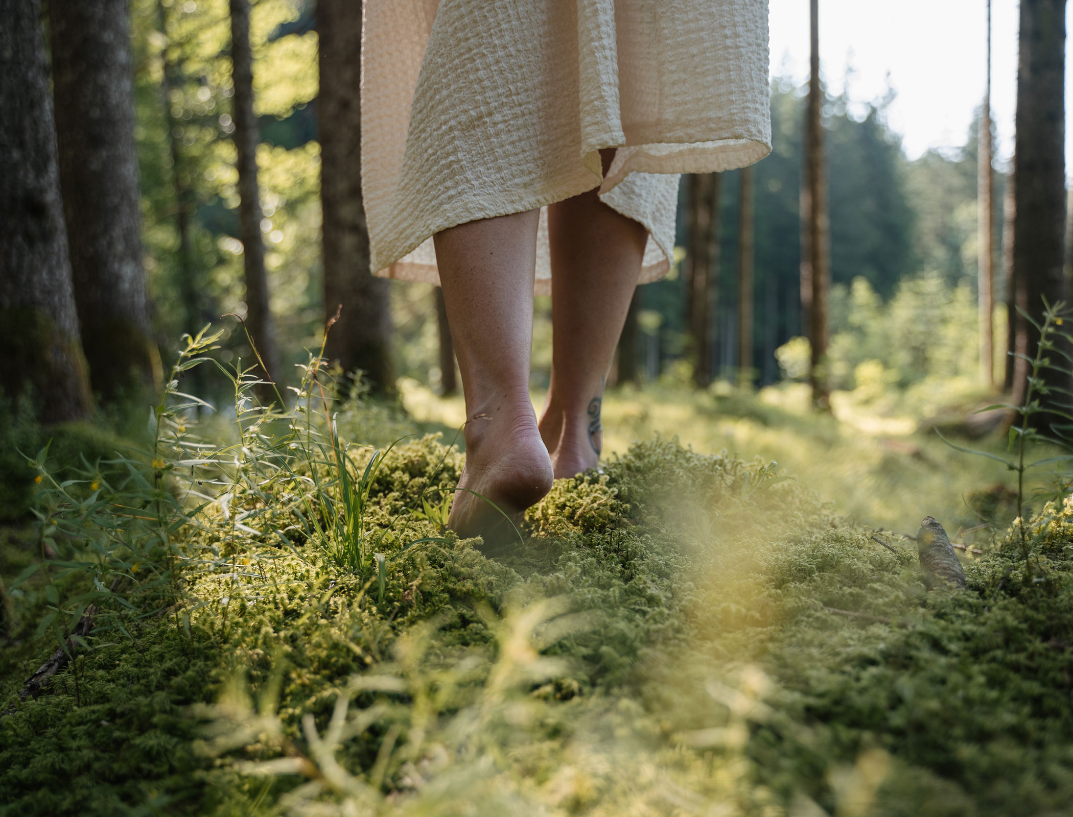 Woman walks barefoot through the forest