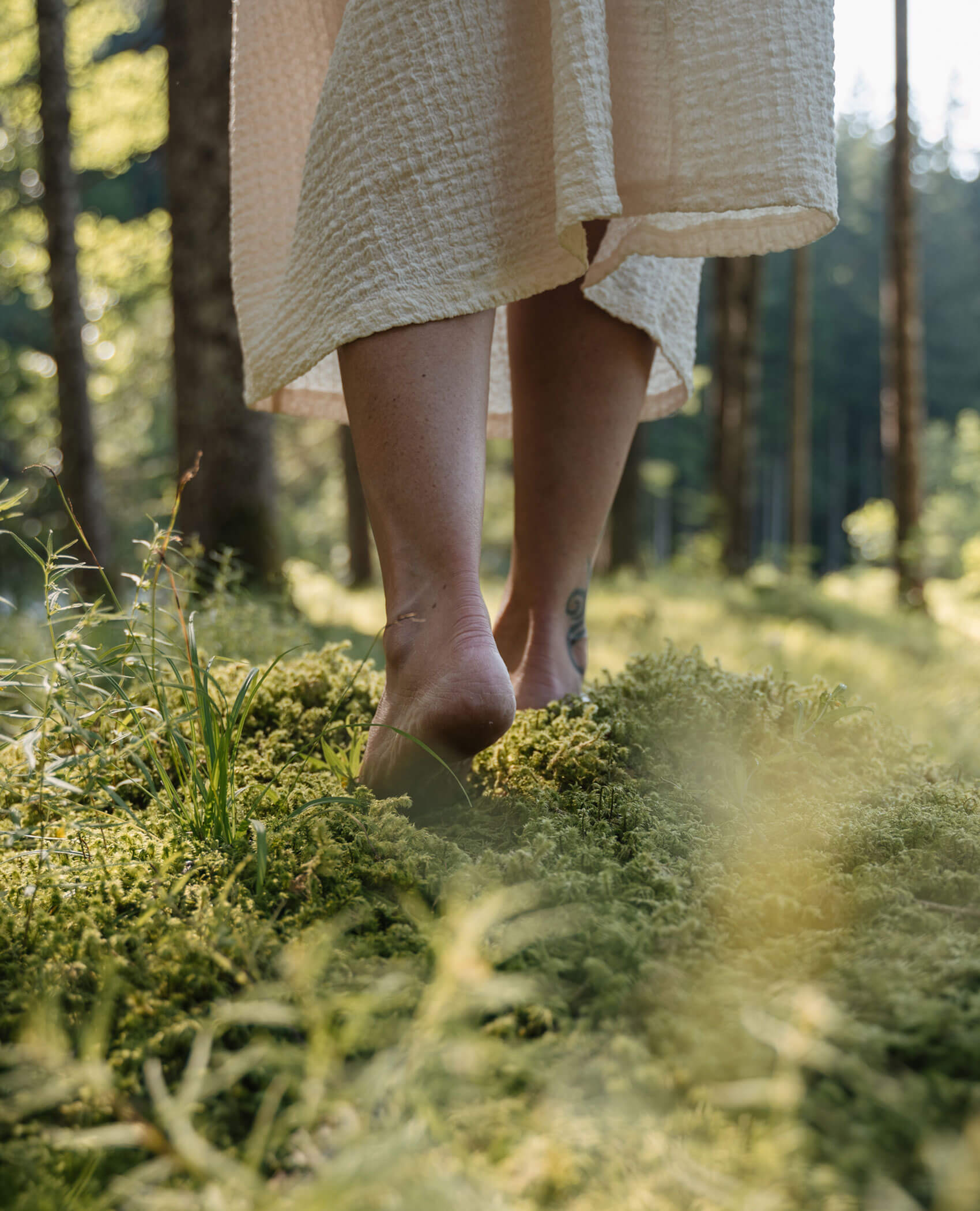 Woman walking barefoot in the forest