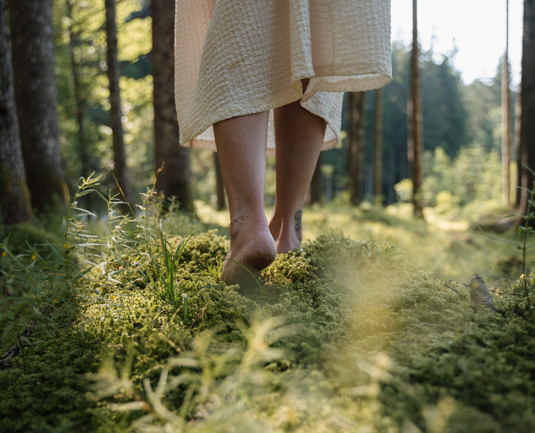 Woman walking barefoot in the forest