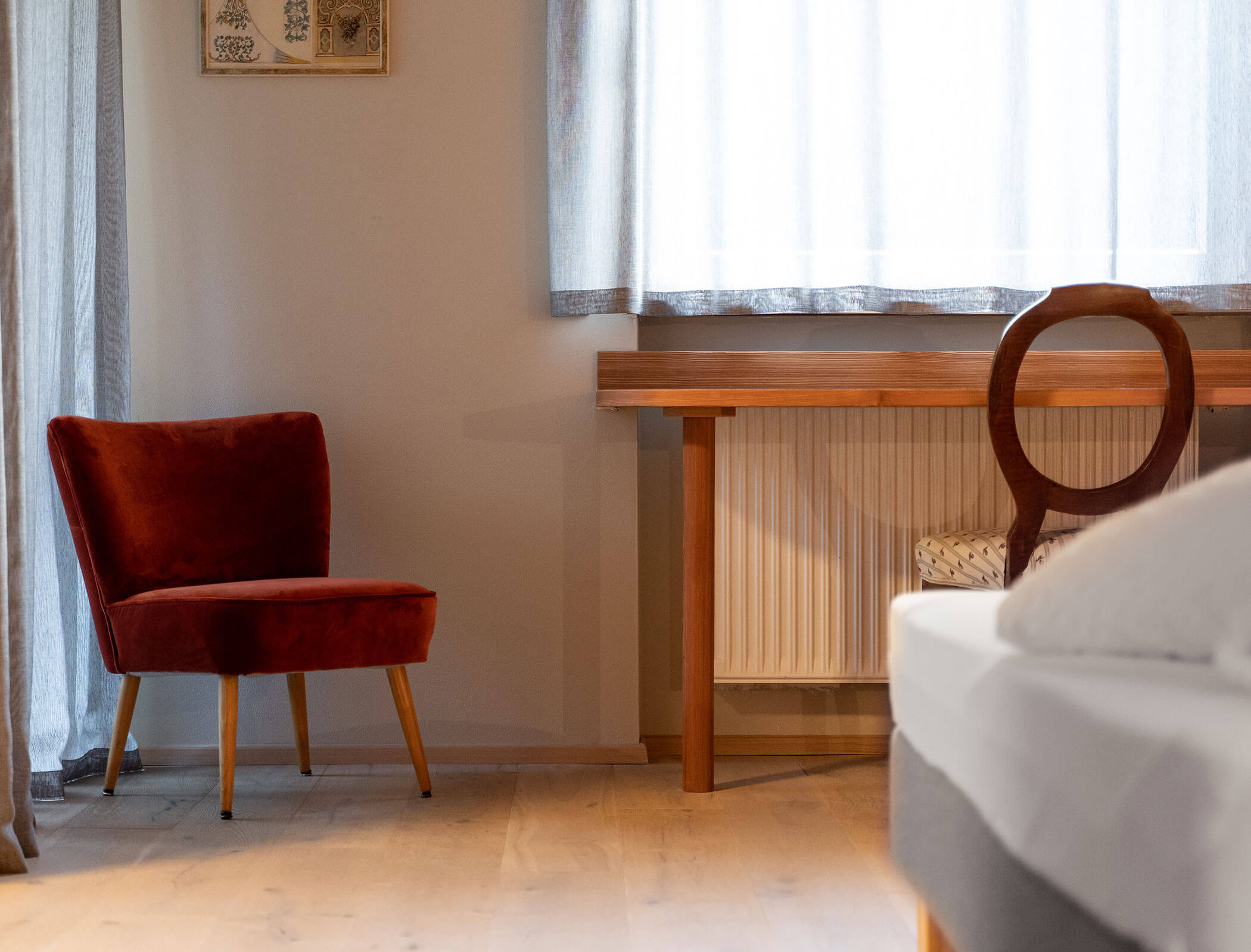 Camera da letto con poltrona rossa e scrivania con sedia in legno - Bad Ratzes
