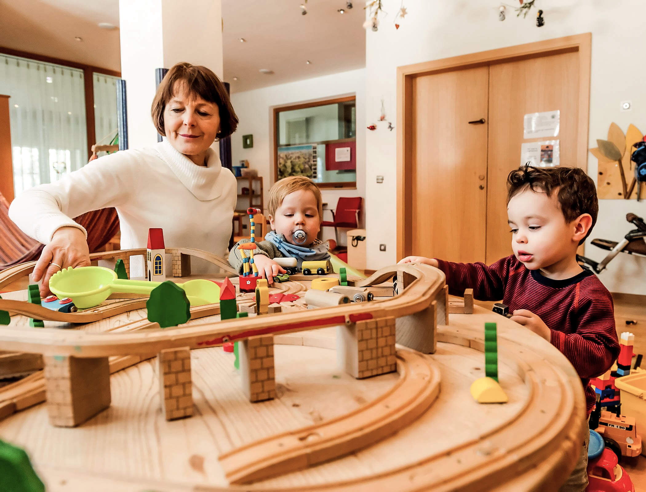 Bambini che giocano con la loro madre sul trenino di legno - Bad Ratzes