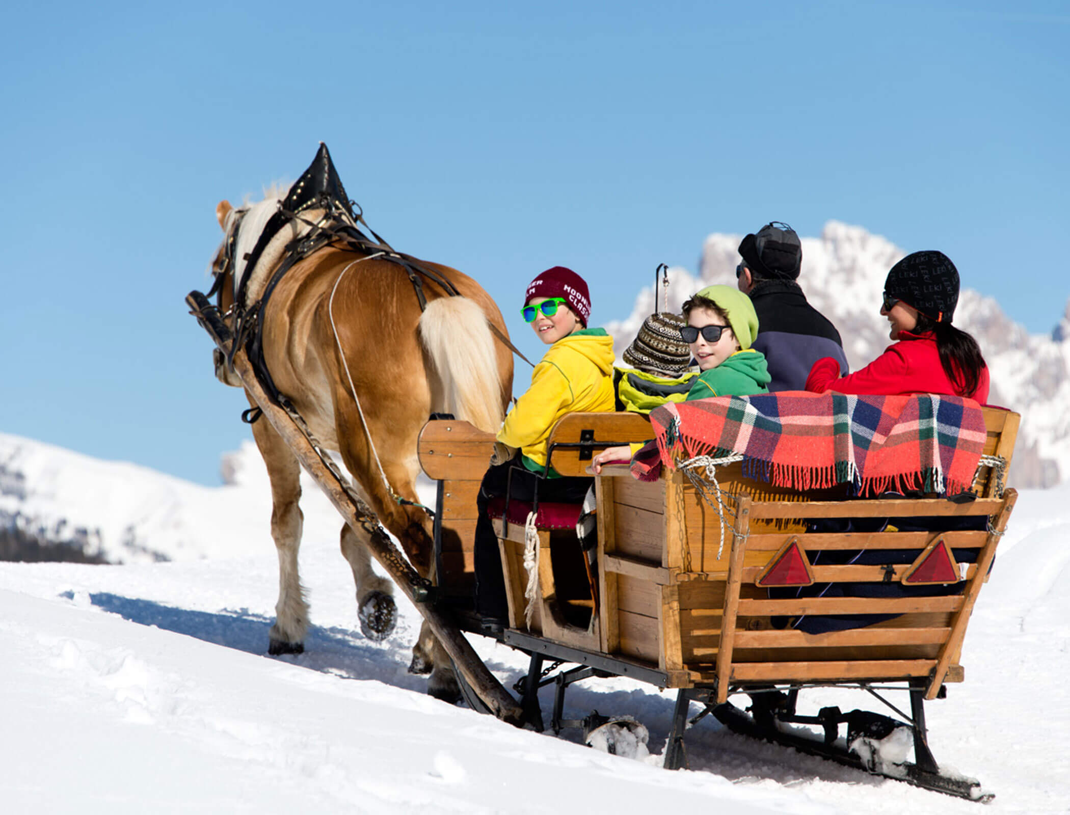 Una famiglia seduta su una slitta trainata da cavalli in inverno - Bad Ratzes
